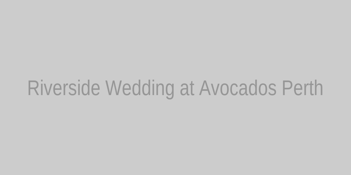A riverside wedding lawn with gum trees, a rustic arbour, and banquet tables at sunset near Perth