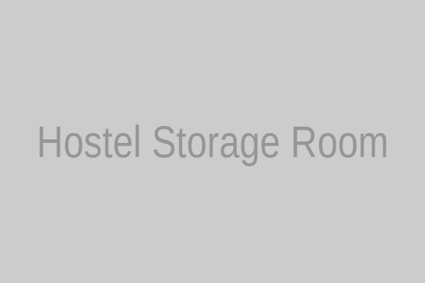 A narrow hostel storage room lined with metal lockers, some with combination locks dangling.