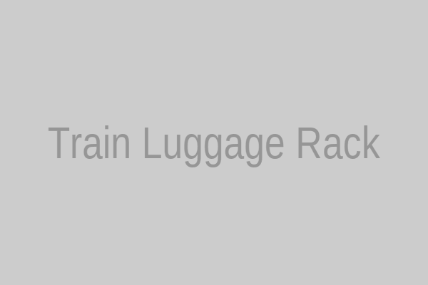 An overnight train compartment with a backpack resting on the overhead luggage rack, next to a sleeping passenger.