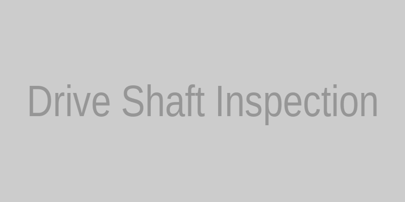 Mechanic inspecting a drive shaft on a vehicle