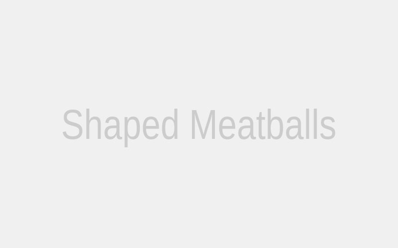 Several perfectly shaped, uniform Asian Meatballs neatly arranged on a parchment-lined baking sheet, ready for the oven.